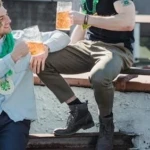 Two men sharing beers and intense eye contact on a rooftop, perfectly embodying the emotional chaos of modern straight guys friendship and bromance tension Image